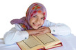 Little girl reads Qoran and smiles