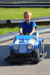 Young boy driving police car on street