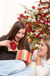 Two smiling women unpacking Christmas present
