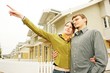 couple in  front of one-family house in modern residential area.