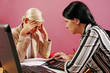 two young women discuss on pink