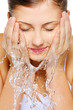 Cute woman wash her  face with water