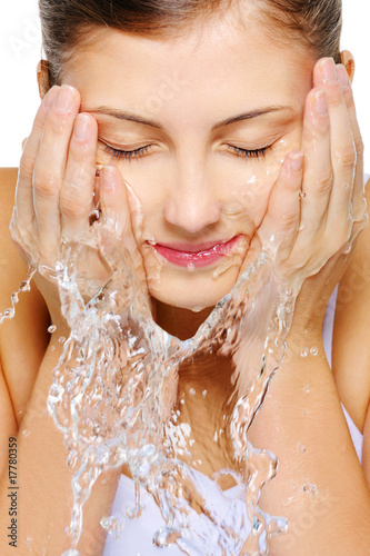 Photo: Cute woman wash her face with water Cute woman wash her face with water