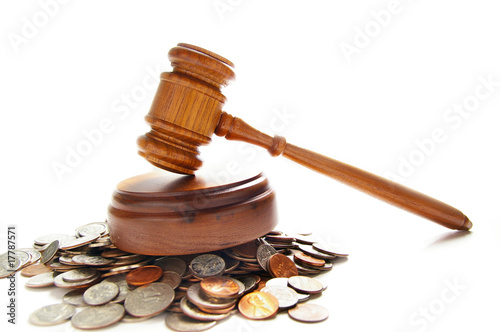 Photo: judges law gavel on a pile of coins, over white judges law gavel on a pile of coins, over white
