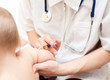 Doctor giving a child an intramuscular injection in arm Doctor giving a child an intramuscular injection in arm