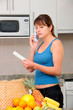 woman checking bill and talking on phone in the kitchen