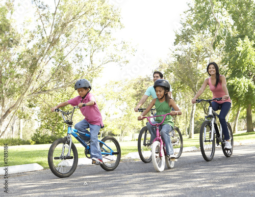 Photo: Young Family Riding Bikes In Park Young Family Riding Bikes In Park