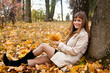 Girl with leaves near a tree