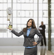 Businesswoman balancing clocks in hand