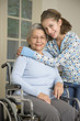 Granddaughter hugging grandmother in wheelchair