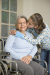 Granddaughter kissing grandmother in wheelchair