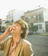 Man laughing and using cell phone outdoors