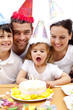 Little girl blowing out candles in her birthday's day