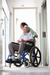 Happy senior man sitting on the wheelchair assisted by his wife