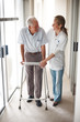 Happy senior patient being assisted by a doctor to walk