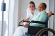 Elderly woman on a wheel chair with a nurse by her Elderly woman on a wheel chair with a nurse by her