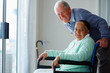 Happy elderly couple , woman on a wheel chair