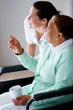 Elderly woman on a wheelchair , nurse pointing away