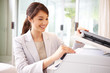 Cute young business woman making photocopies