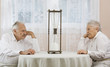 Senior couple staring at hourglass