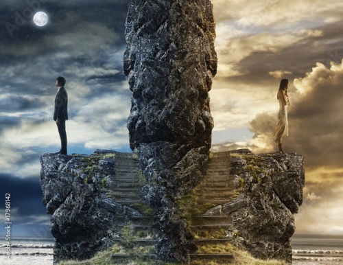 Photo: Mixed Race couple standing on opposite sides of rock ledge Mixed Race couple standing on opposite sides of rock ledge