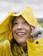 Hispanic woman wearing raincoat in rain