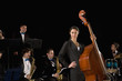 Woman holding upright bass in front of band