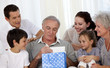 Family giving to grandfather a present