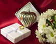 Gift box with a heart decoration, flowers and a golden ring Gift box with a heart decoration, flowers and a golden ring