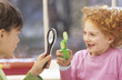 Photo: Boy and girl (8-9) with magnifying glass Boy and girl (8-9) with magnifying glass