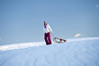 Young woman in snow with sleigh