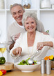 Foto: Happy senior couple eeating a salad in the kitchen Happy senior couple eeating a salad in the kitchen