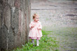 Small cute girl standing near old wall and pointing at herself Small cute girl standing near old wall and pointing at herself
