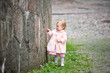 Small cute girl standing near old wall and painting graffiti Small cute girl standing near old wall and painting graffiti
