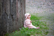 Small cute girl sitting near old wall Small cute girl sitting near old wall