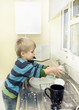 Foto: Child plays with soap and water at the kitchen sink. Child plays with soap and water at the kitchen sink.