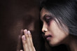 Injured woman leaning sadly on wooden wall