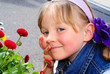 Das Gesicht des Kindes in der Nähe der Blumen.