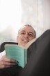 Mid adult man relaxing at home reading a book