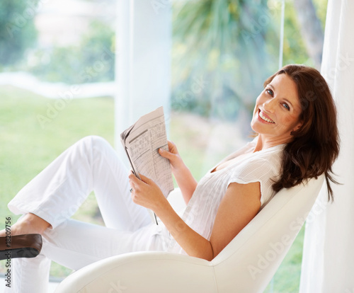 Foto: Portrait of a cheerful woman holding newspaper Portrait of a cheerful woman holding newspaper