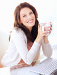 Foto: Portrait of woman holding coffee cup by laptop Portrait of woman holding coffee cup by laptop