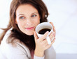 Foto: Happy woman having coffee looking away in thought Happy woman having coffee looking away in thought
