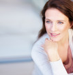 Happy woman with hand on chin thinking Happy woman with hand on chin thinking