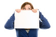 Woman covering face with blank note card and looking up