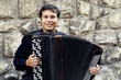 Male playing on the accordion against a grunge background