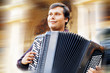 Male playing on the accordion against a grunge background