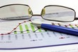 Glasses and pen upon the graph