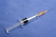 One small glass syringe in blue background