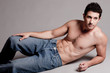 Lying muscular man looking at the left corner Lying muscular man looking at the left corner