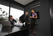 Businesswoman pulling businessman's tie